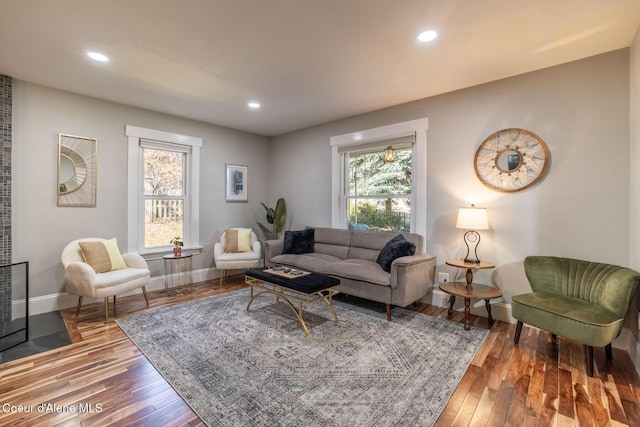 living area with baseboards, wood-type flooring, and recessed lighting