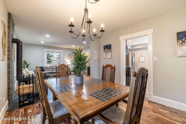 dining space featuring wood finished floors, a chandelier, baseboards, and recessed lighting