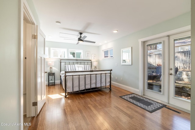 bedroom with access to outside, wood finished floors, baseboards, french doors, and recessed lighting