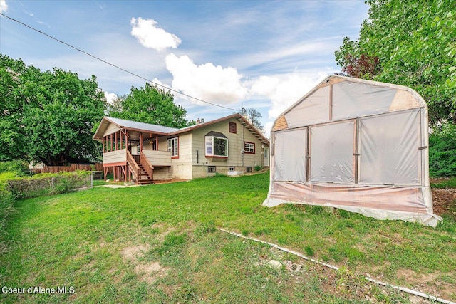 342 Summit Blvd, Priest River, ID 83856 - rear view of house with a sunroom, a lawn, stairway, an outdoor structure, and metal roof