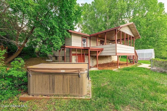342 Summit Blvd, Priest River, ID 83856 - rear view of house featuring a hot tub, an exterior structure, a lawn, an outdoor structure, and a sunroom