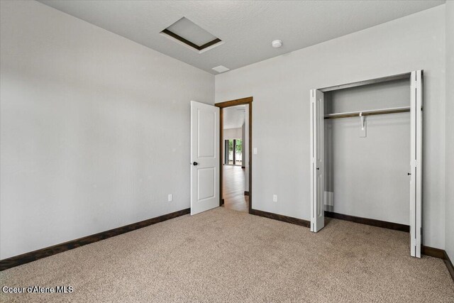 2060 E Plaza Ct, Post Falls, ID 83854 - unfurnished bedroom with light colored carpet, baseboards, a closet, attic access, and vaulted ceiling