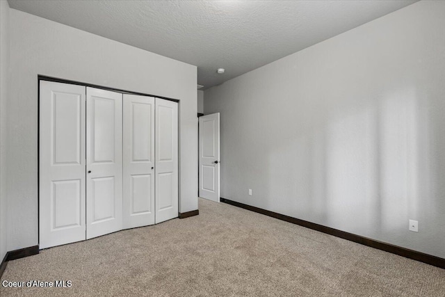 2060 E Plaza Ct, Post Falls, ID 83854 - unfurnished bedroom with carpet flooring, a closet, a textured ceiling, and baseboards
