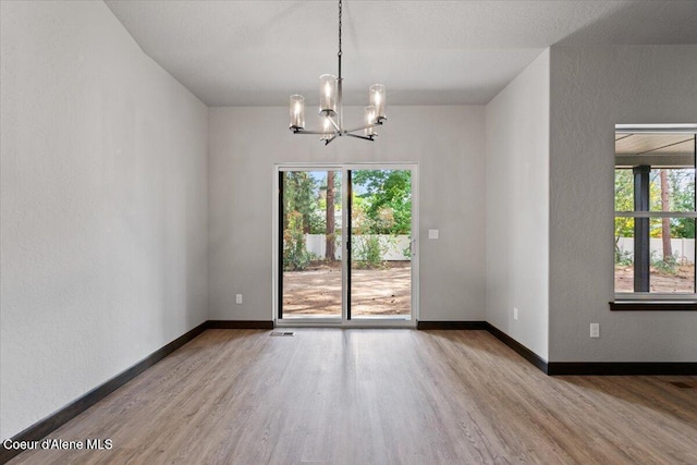 2060 E Plaza Ct, Post Falls, ID 83854 - unfurnished room with a chandelier, wood finished floors, baseboards, and a textured wall