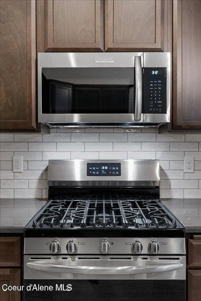 2060 E Plaza Ct, Post Falls, ID 83854 - kitchen view of appliances with stainless steel finishes, dark brown cabinetry, and backsplash
