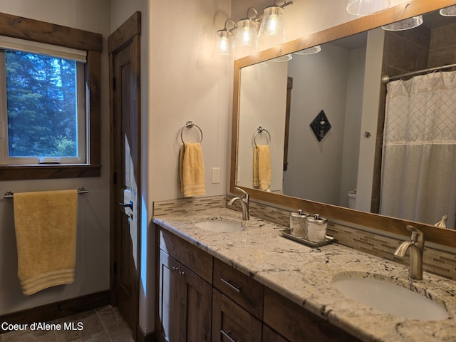 12552 N Walden Loop, Rathdrum, ID 83858 - bathroom featuring double vanity, backsplash, toilet, curtained shower, and tile patterned flooring