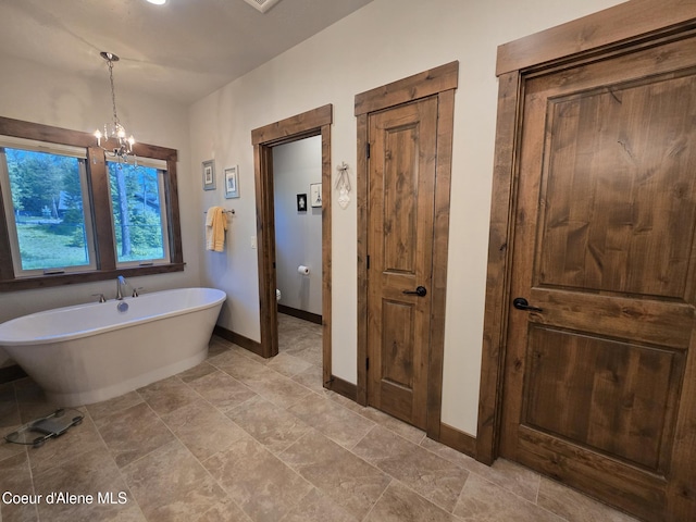 12552 N Walden Loop, Rathdrum, ID 83858 - full bath featuring a freestanding tub, baseboards, a chandelier, and toilet