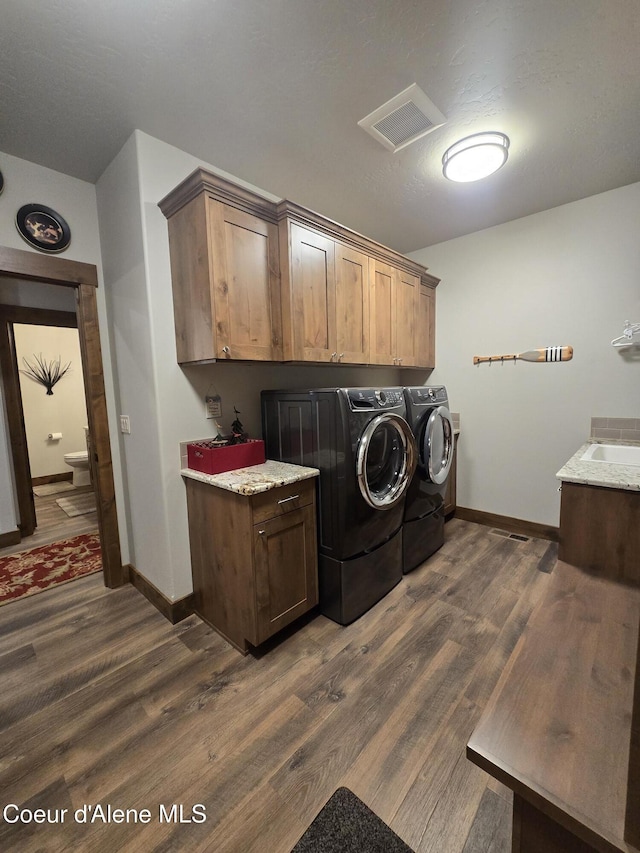 12552 N Walden Loop, Rathdrum, ID 83858 - laundry room featuring separate washer and dryer, cabinet space, baseboards, and dark wood finished floors