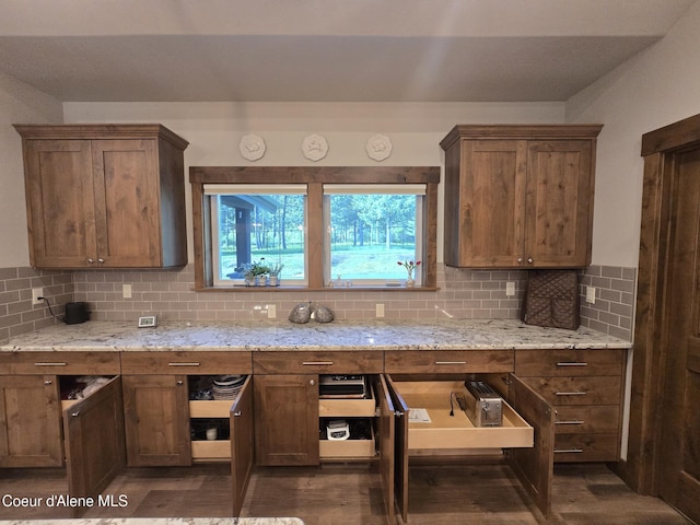 12552 N Walden Loop, Rathdrum, ID 83858 - kitchen featuring backsplash, light stone counters, and dark wood finished floors