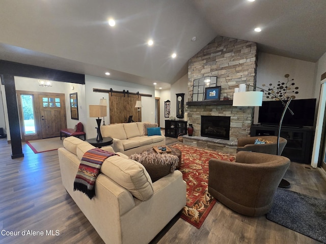 12552 N Walden Loop, Rathdrum, ID 83858 - living room with wood finished floors, a barn door, a fireplace, recessed lighting, and high vaulted ceiling