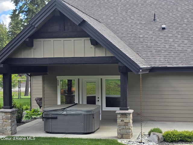 12552 N Walden Loop, Rathdrum, ID 83858 - back of house featuring a hot tub, roof with shingles, a patio, and board and batten siding