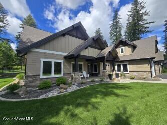 12552 N Walden Loop, Rathdrum, ID 83858 - back of house featuring stone siding, a yard, and board and batten siding
