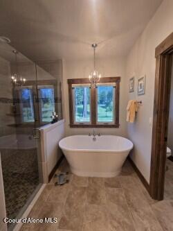 12552 N Walden Loop, Rathdrum, ID 83858 - bathroom with a chandelier, a shower stall, a freestanding bath, and toilet