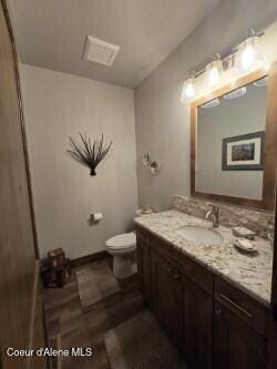 12552 N Walden Loop, Rathdrum, ID 83858 - bathroom featuring vanity, toilet, and wood finished floors