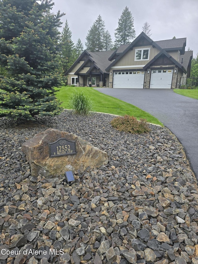 12552 N Walden Loop, Rathdrum, ID 83858 - view of front of home featuring driveway, an attached garage, a front yard, and board and batten siding