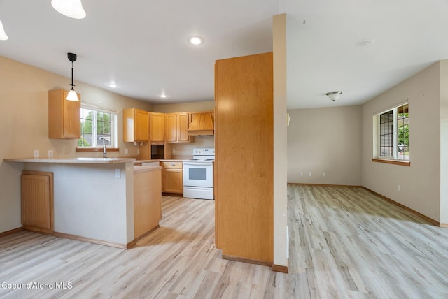 410 Humbird St, Kootenai, ID 83840 - kitchen featuring electric stove, light wood-style flooring, light countertops, custom range hood, and a peninsula