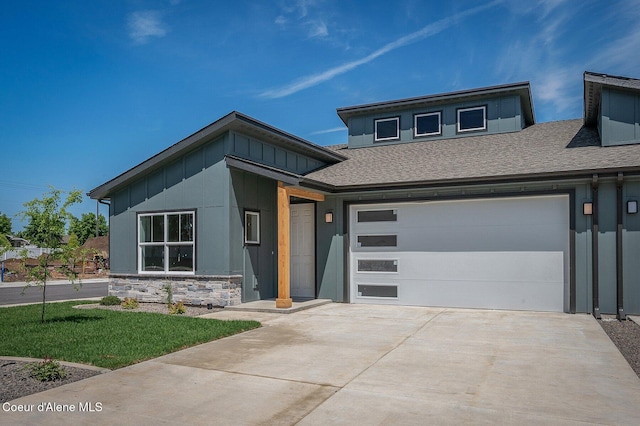 7414 N Breaux Dr, Coeur Dalene, ID 83815 - view of front of home with board and batten siding, concrete driveway, stone siding, a front yard, and a shingled roof