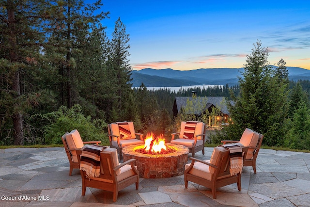 7783 S Buckrail Rd, Harrison, ID 83833 - view of patio featuring an outdoor fire pit, a mountain view, and a view of trees