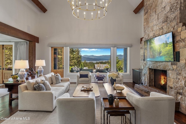 7783 S Buckrail Rd, Harrison, ID 83833 - living area with high vaulted ceiling, beamed ceiling, wood finished floors, a fireplace, and a chandelier