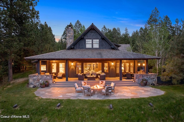 7783 S Buckrail Rd, Harrison, ID 83833 - back of house featuring an outdoor living space with a fire pit, a patio, a chimney, and a lawn