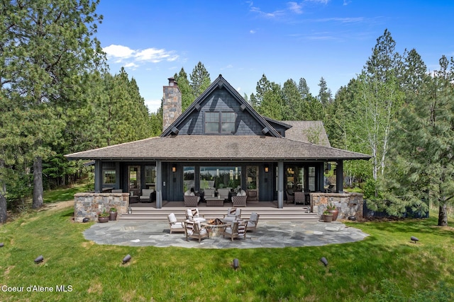 7783 S Buckrail Rd, Harrison, ID 83833 - rear view of property featuring a patio area, an outdoor living space with a fire pit, a yard, and a chimney