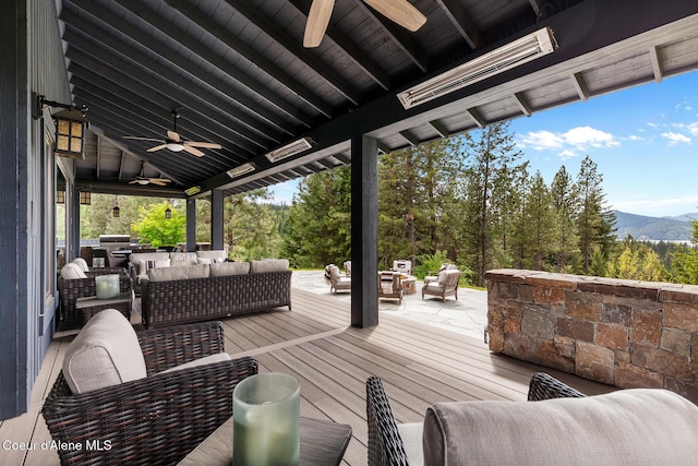 7783 S Buckrail Rd, Harrison, ID 83833 - wooden terrace featuring a ceiling fan, an outdoor living space with a fire pit, and a mountain view