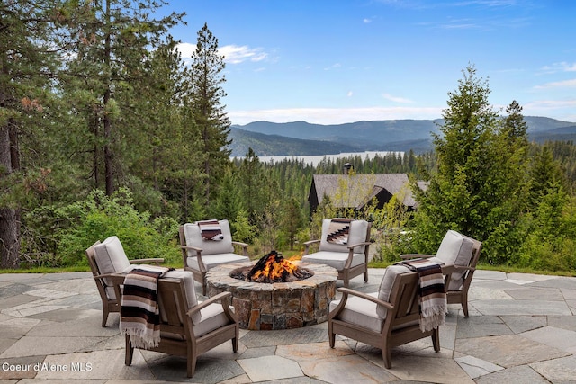 7783 S Buckrail Rd, Harrison, ID 83833 - view of patio with an outdoor fire pit, a mountain view, and a wooded view