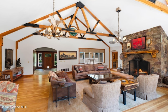 2672 Merril Martin Rd, Sagle, ID 83860 - living room with arched walkways, a chandelier, high vaulted ceiling, light wood finished floors, and a stone fireplace