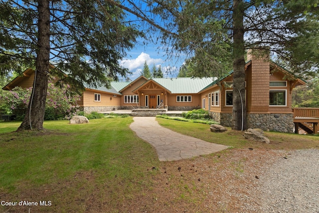2672 Merril Martin Rd, Sagle, ID 83860 - view of front of house featuring stone siding, a front lawn, a metal roof, and a chimney