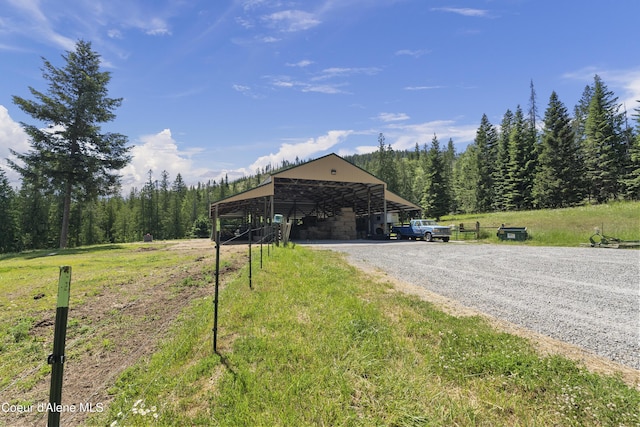 2672 Merril Martin Rd, Sagle, ID 83860 - view of pole building with gravel driveway, a garage, a wooded view, and a carport