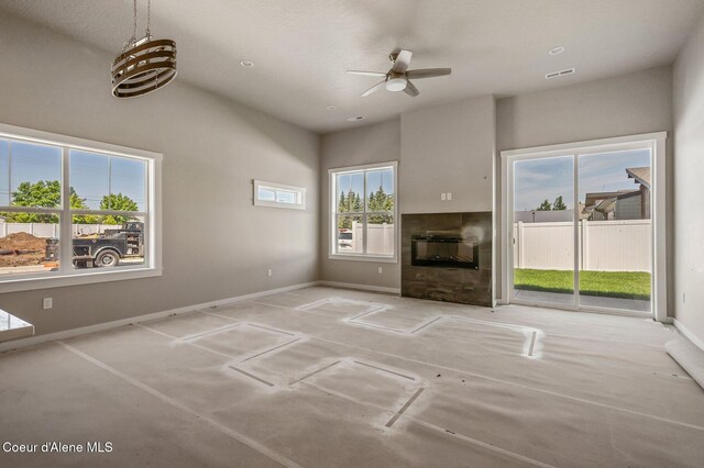 7388 N Breaux Dr, Coeur Dalene, ID 83815 - unfurnished living room with a ceiling fan, a tiled fireplace, and baseboards