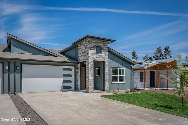 7388 N Breaux Dr, Coeur Dalene, ID 83815 - modern home featuring board and batten siding, driveway, a garage, roof with shingles, and stone siding