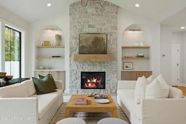 11947 N Rocking R Rd, Hayden, ID 83835 - living area with lofted ceiling, built in features, a stone fireplace, wood finished floors, and recessed lighting