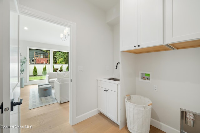 11947 N Rocking R Rd, Hayden, ID 83835 - washroom with cabinet space, washer hookup, light wood-style flooring, and baseboards