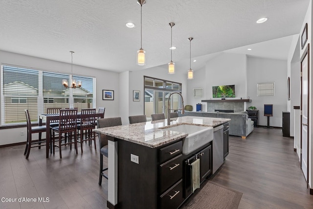 4463 E Marble Fox Ave, Post Falls, ID 83854 - kitchen with a sink, a breakfast bar area, dark cabinetry, dark wood-style flooring, and vaulted ceiling