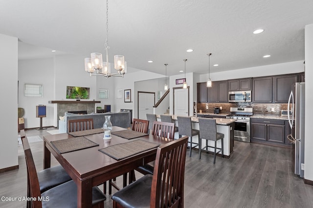 4463 E Marble Fox Ave, Post Falls, ID 83854 - dining area with recessed lighting, dark wood-type flooring, a chandelier, baseboards, and a tiled fireplace