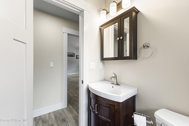 193 Grouse Rd, Sandpoint, ID 83864 - bathroom with vanity, toilet, wood finished floors, and baseboards