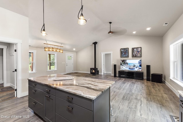193 Grouse Rd, Sandpoint, ID 83864 - kitchen with a wood stove, healthy amount of natural light, open floor plan, light wood-type flooring, and vaulted ceiling