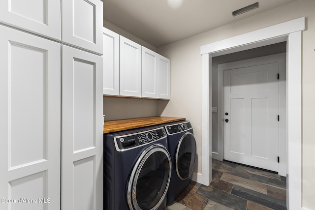 193 Grouse Rd, Sandpoint, ID 83864 - laundry room featuring washing machine and dryer, cabinet space, dark stone finish flooring, and baseboards