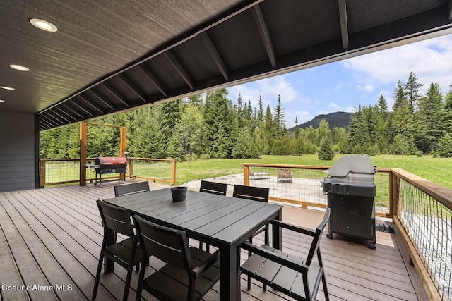 193 Grouse Rd, Sandpoint, ID 83864 - wooden terrace with area for grilling, outdoor dining area, a view of trees, and a lawn