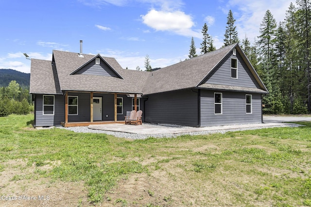 193 Grouse Rd, Sandpoint, ID 83864 - rear view of house featuring roof with shingles, a yard, and a porch