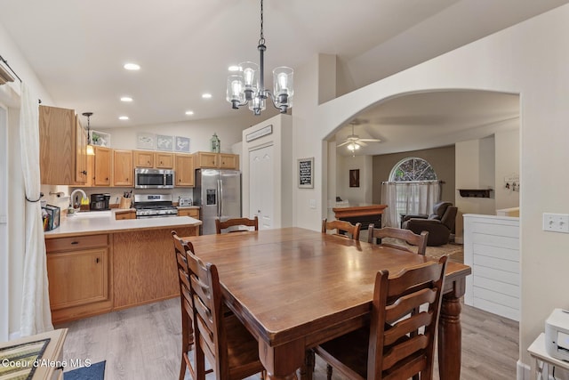 821 W Mustang Ave, Hayden, ID 83835 - dining space featuring light wood-type flooring, arched walkways, ceiling fan, a chandelier, and recessed lighting