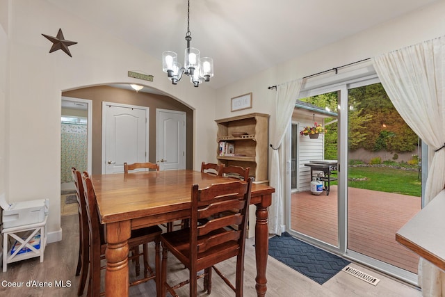 821 W Mustang Ave, Hayden, ID 83835 - dining space with arched walkways, wood finished floors, a chandelier, lofted ceiling, and baseboards