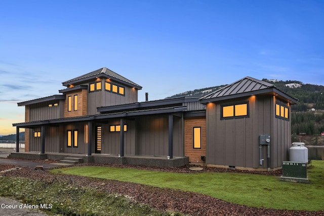1808 Garfield Bay Rd, Sagle, ID 83860 - view of front of property featuring a standing seam roof, a porch, metal roof, a lawn, and board and batten siding
