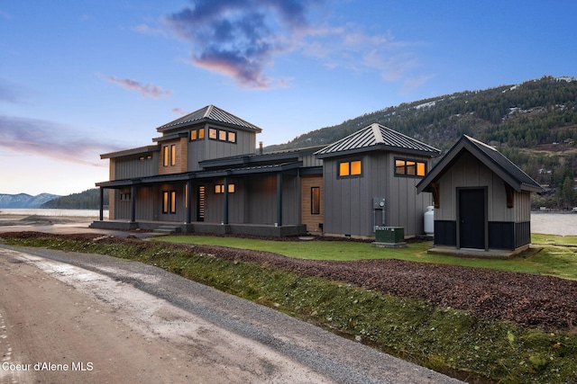 1808 Garfield Bay Rd, Sagle, ID 83860 - view of front of house with a porch, board and batten siding, central air condition unit, metal roof, and a standing seam roof