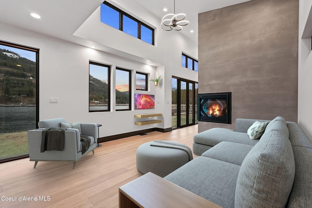 1808 Garfield Bay Rd, Sagle, ID 83860 - living area with light wood-style floors, a chandelier, a large fireplace, baseboards, and recessed lighting