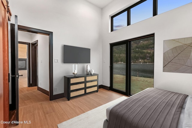 1808 Garfield Bay Rd, Sagle, ID 83860 - bedroom featuring light wood finished floors, access to outside, baseboards, and a high ceiling