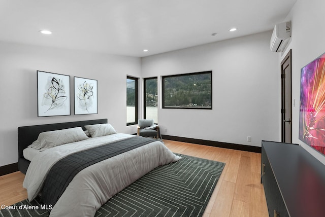 1808 Garfield Bay Rd, Sagle, ID 83860 - bedroom featuring a wall mounted AC, recessed lighting, light wood-style floors, and baseboards