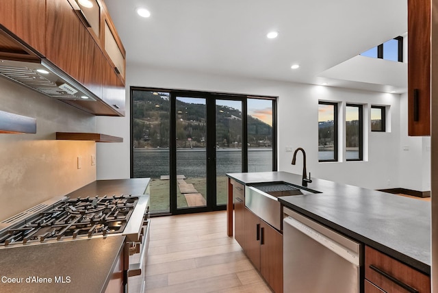 1808 Garfield Bay Rd, Sagle, ID 83860 - kitchen featuring appliances with stainless steel finishes, a sink, dark countertops, custom range hood, and open shelves