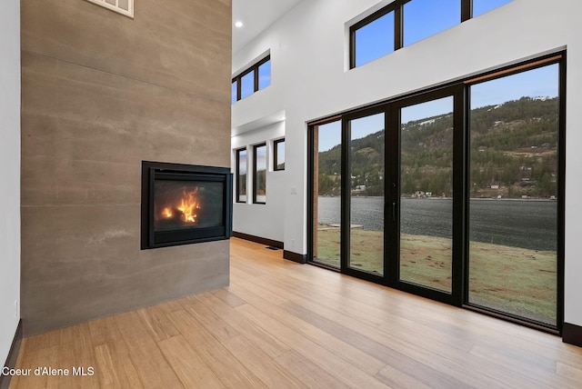 1808 Garfield Bay Rd, Sagle, ID 83860 - foyer entrance featuring wood finished floors, a towering ceiling, a multi sided fireplace, and baseboards